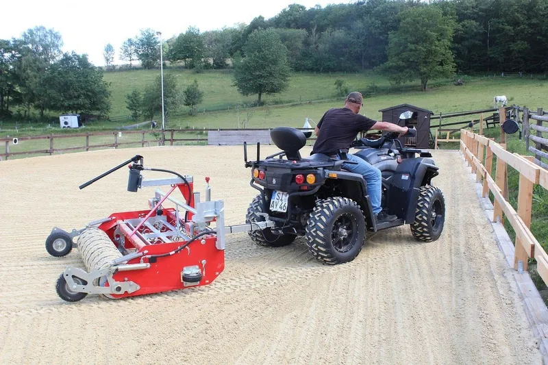 Floor-Care AHK 145/200 manegevlakker achter een quad in een buitenbak