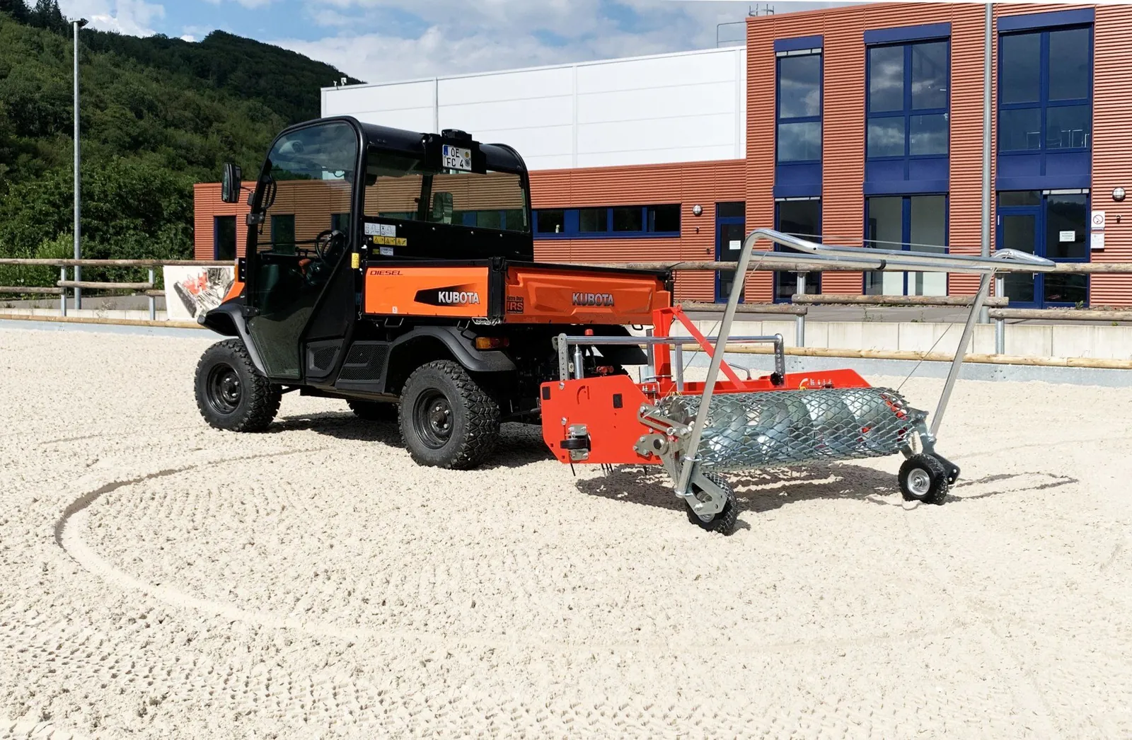 Floor-Care AHK 145/200 achter een oranje Kubota-UTV in een zandbak