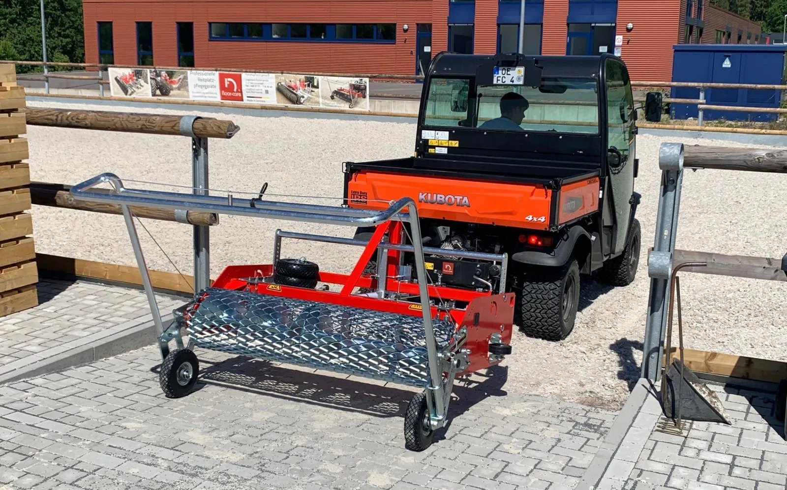 Floor-Care AHK 145/200 met beugel en een oranje Kubota-UTV erachter