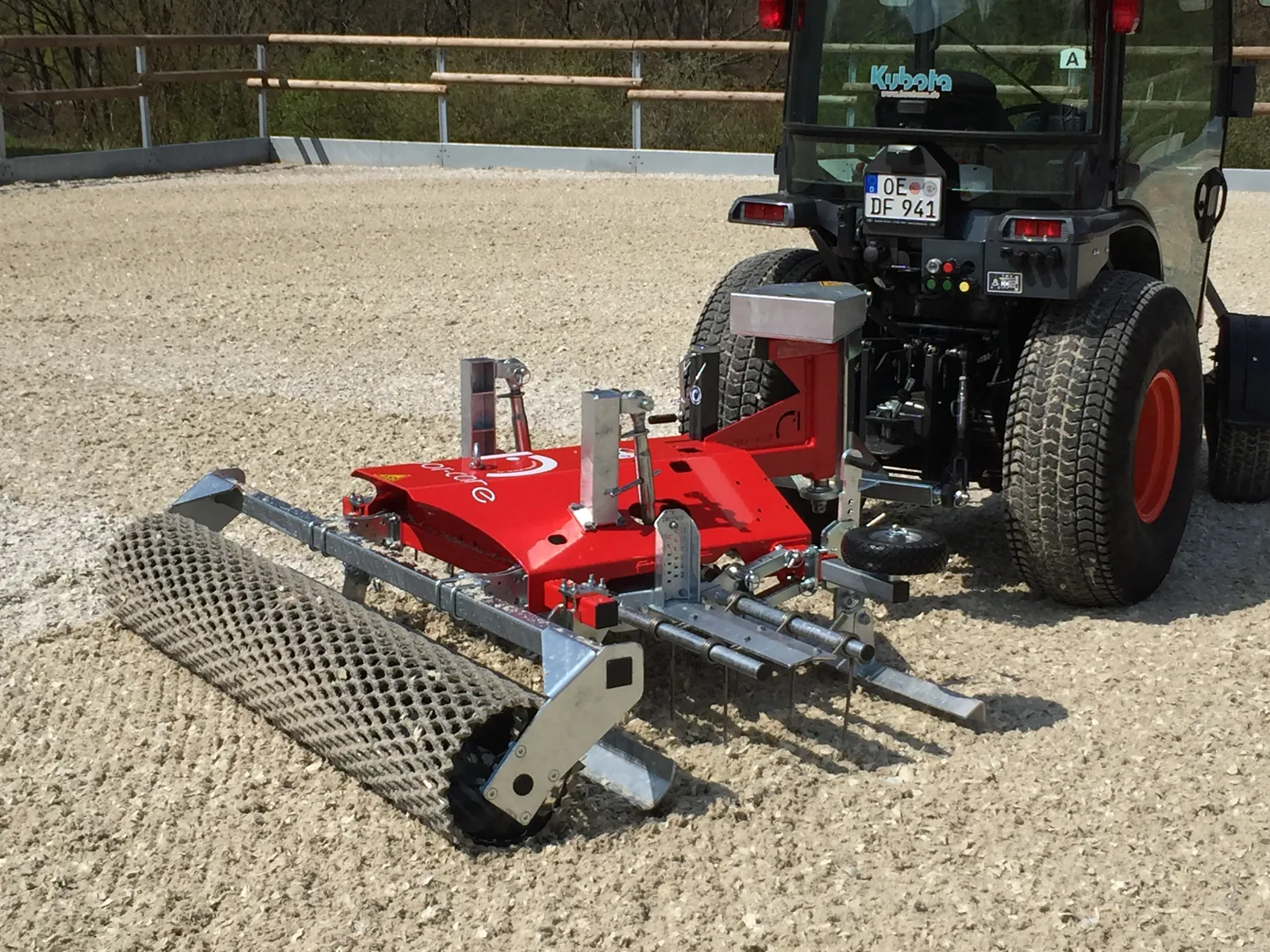 Floor-Care ONE achter een zwarte Kubota-trekker, schuin van achteren